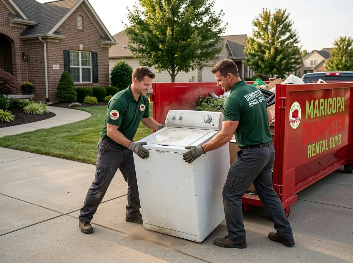 Crew lifting an appliance into a roll-off container during a cleanout